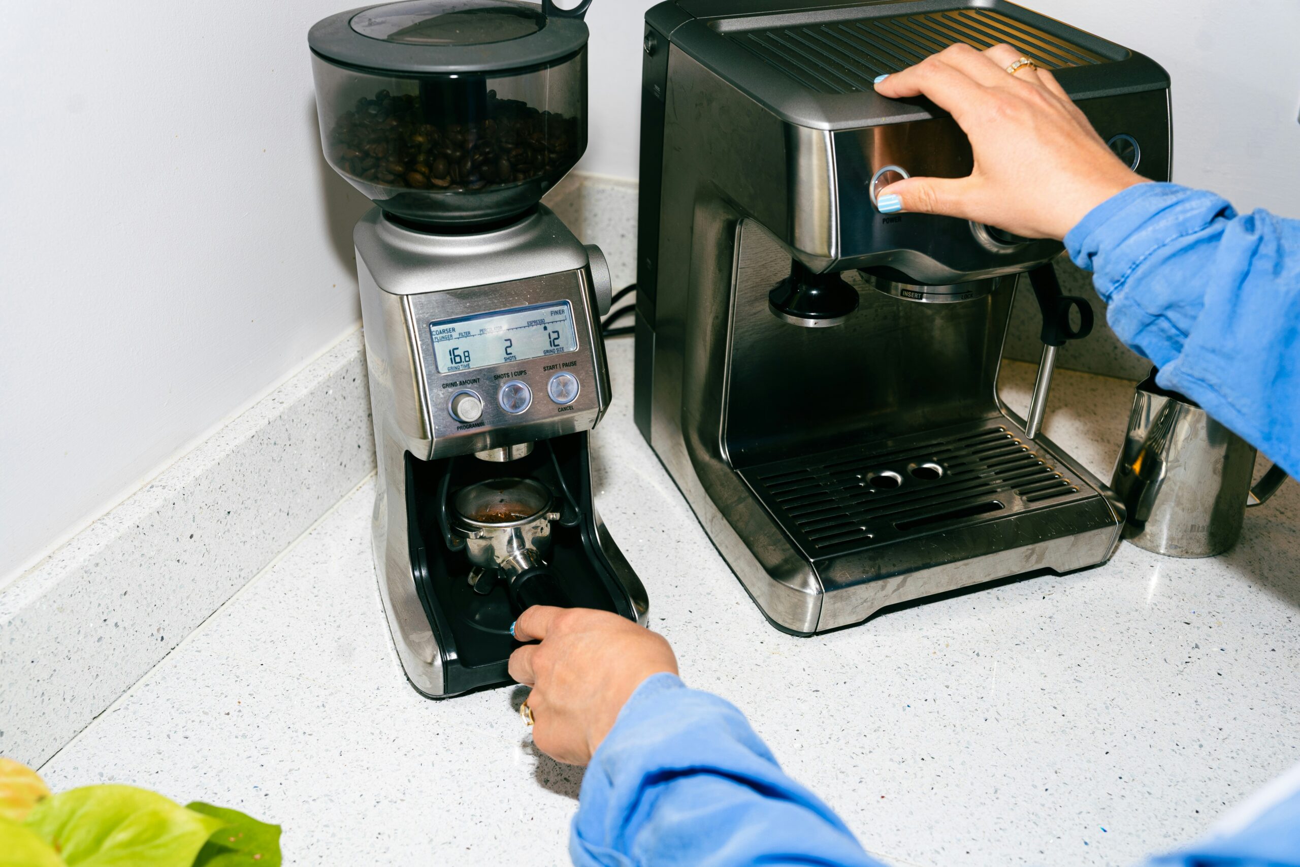 Uma pessoa fazendo café na cafeteira programável.