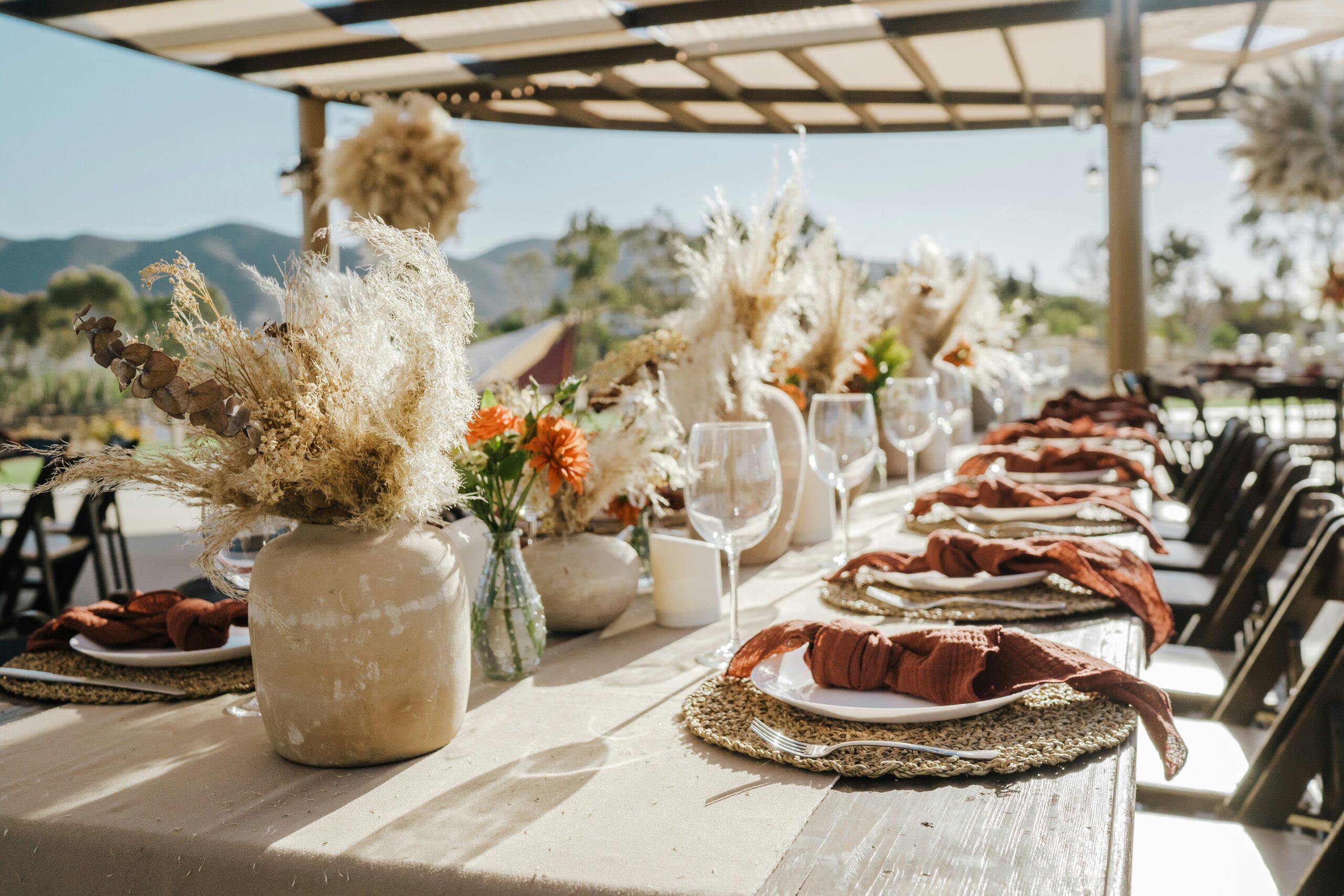Mesa posta com aparelho de jantar completo em um restaurante com vista para a praia.