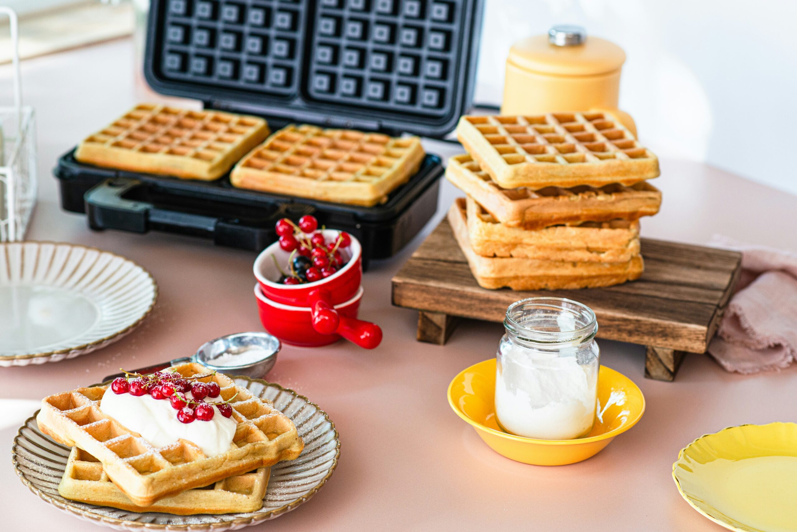 Máquina de waffle ligada na bancada da cozinha durante o preparo de um café da manhã.