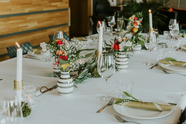 Mesa posta refinada para casamento destacando um conjunto de pratos elegantemente organizado.