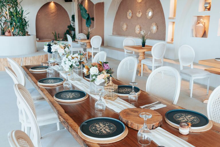 Mesa montada em um restaurante destacando conjuntos de pratos elegantes e organizados.