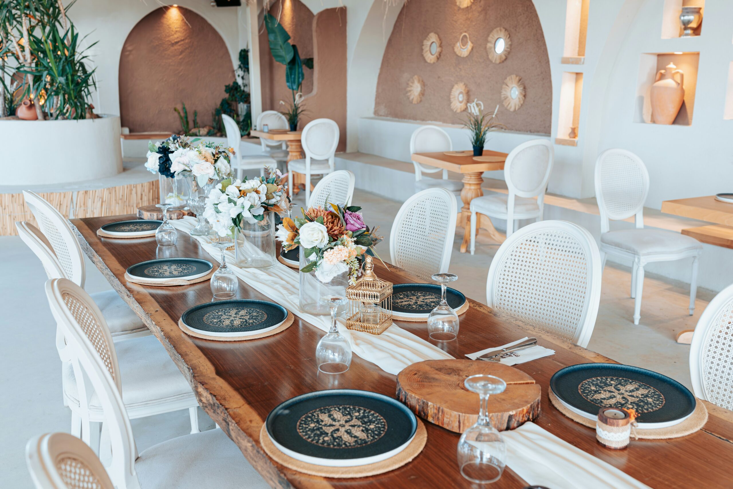 Mesa montada em um restaurante destacando conjuntos de pratos elegantes e organizados.